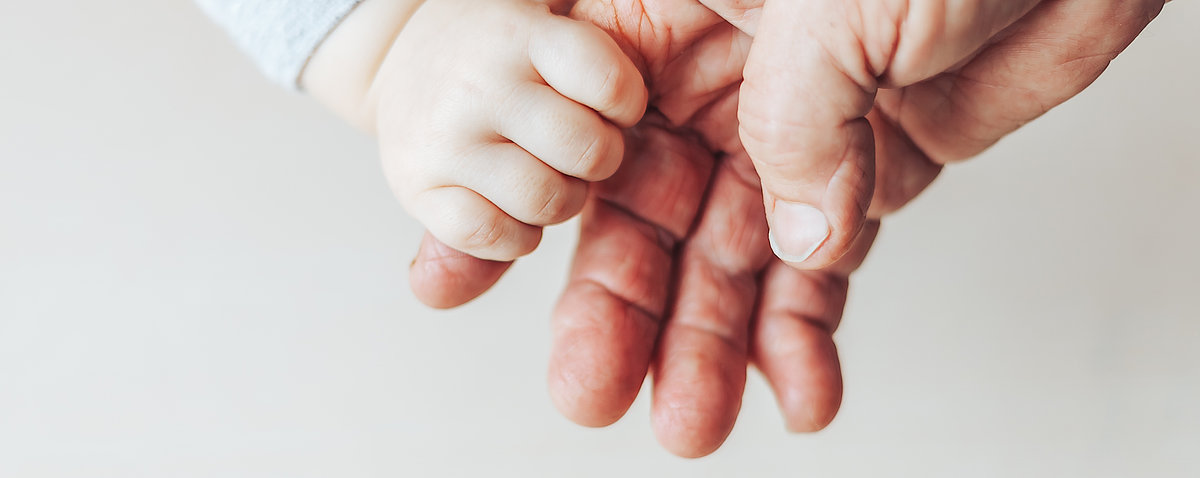Kleine Kinderhand umfasst vertrauensvoll eine ältere Hand – als Symbolbild für das Thema Mehrwegzuschuss.