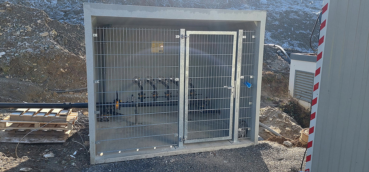 Metallgitter-Schrank mit mehreren Gasventilen in einem Betonrahmen, installiert im Außenbereiche der AWRM – technische Anlage für die Hauptgasversorgung.