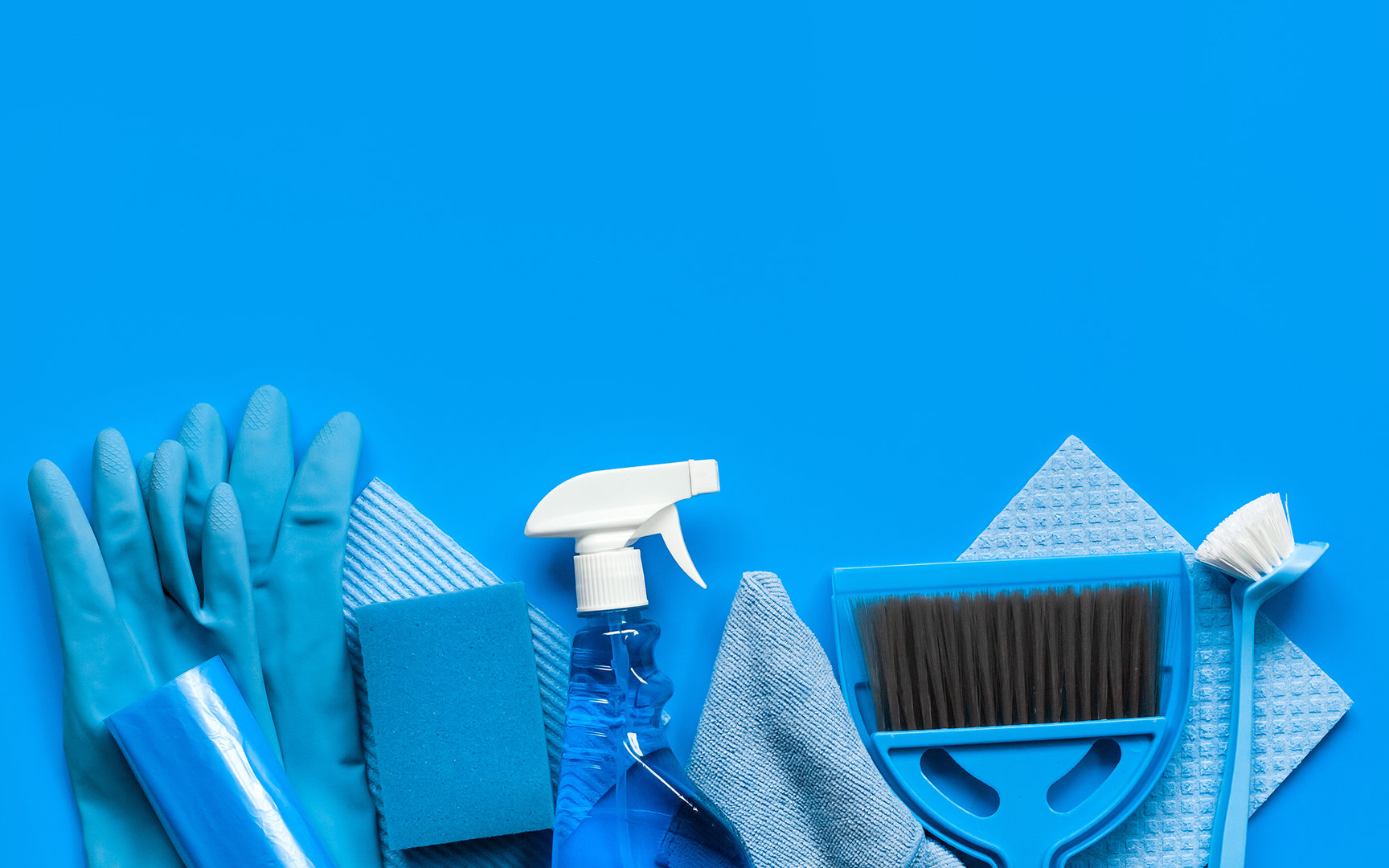 Verschiedene Reinigungsutensilien wie Handschuhe, Schwämme, Tücher, Besen und Sprühflasche in Blau auf blauem Hintergrund.