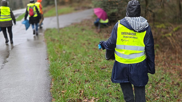 Menschen mit Warnweste beim Müllsammeln