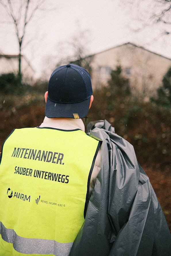 Person mit AWRM-Warnweste und Basecap von hinten