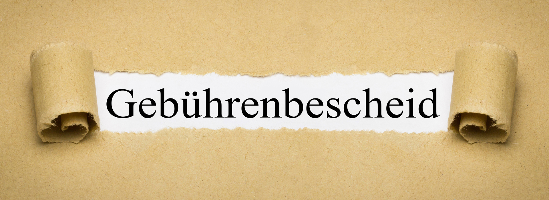 Aufgerissenes Packpapier legt das Wort „Gebührenbescheid“ in schwarzer Serifenschrift frei.